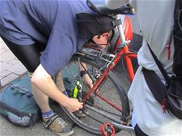 Olly carries out temporary repairs for his broken rear wheel spindle outside Jona-Rapperswil Youth Hostel